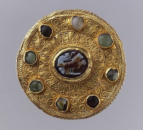 Золотая круглая брошь мастеров из лангобардских племён. По центру - античная камея, II - III век нашей эры, по бокам - опалы, агаты и гранаты более позднего периода.